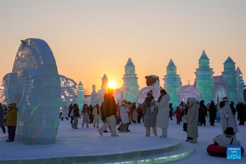 Turistas se divertem ao pôr do sol no Mundo de Gelo e Neve de Harbin, no nordeste da China