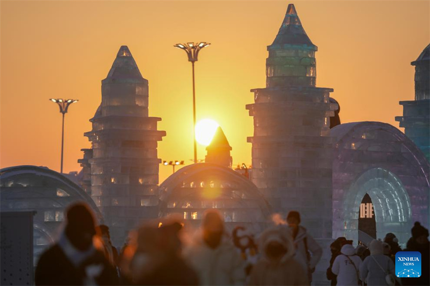 Turistas se divertem ao pôr do sol no Mundo de Gelo e Neve de Harbin, no nordeste da China